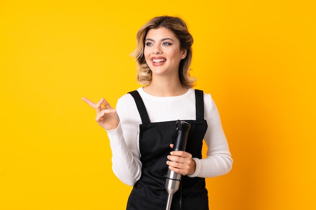 Woman using hand blender in studio