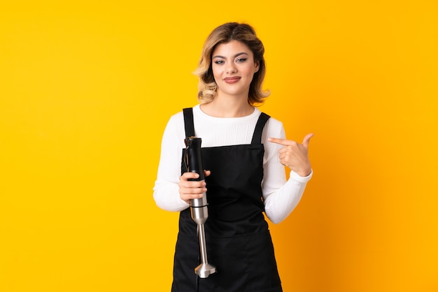 Woman using hand blender in studio