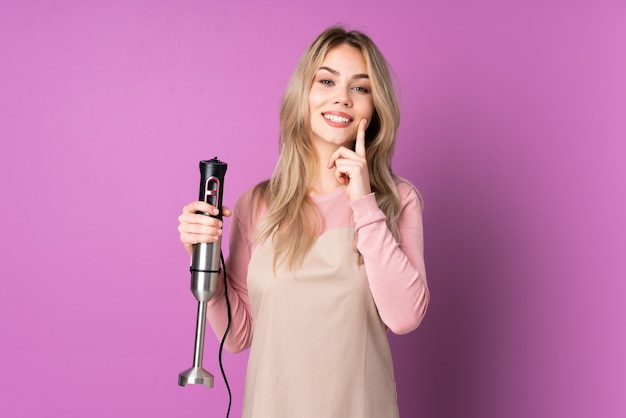 Woman using hand blender in studio