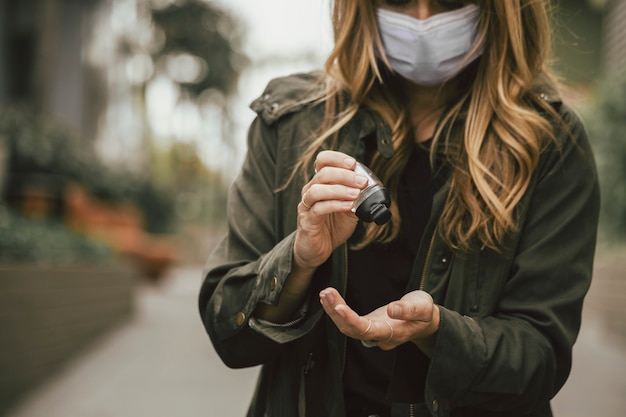 Woman using a hand sanitizer during coronavirus pandemic