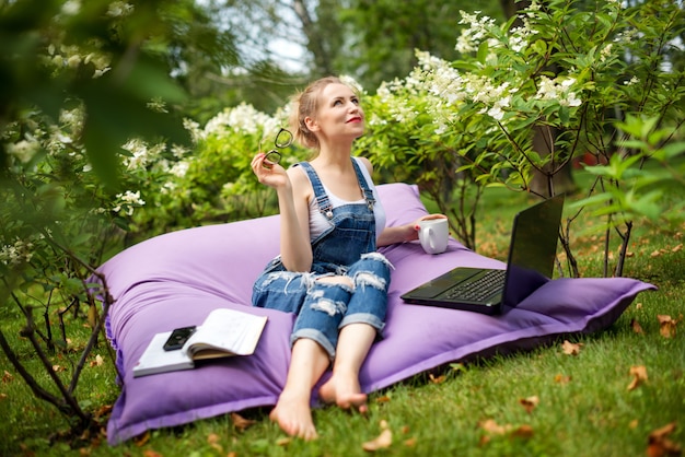 Donna che utilizza il suo computer portatile nel giardino