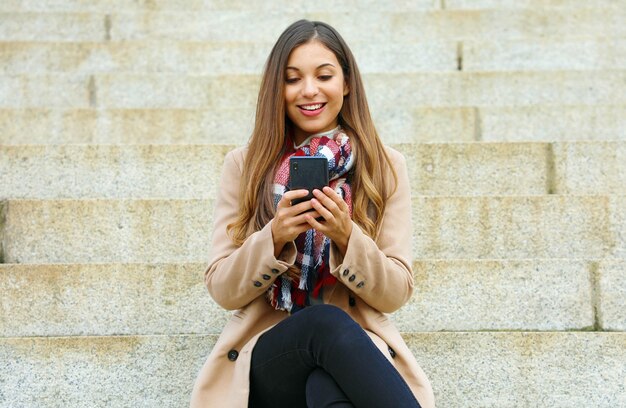 街を歩きながら彼女の電話を使用している女性