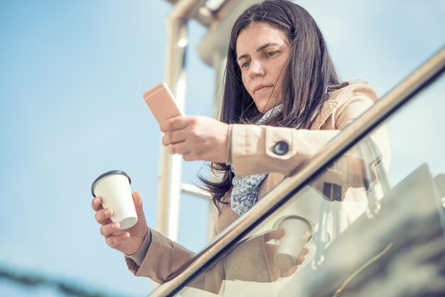 Donna che per mezzo del suo telefono astuto