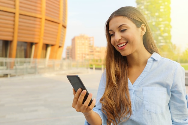 彼女のスマートフォンを屋外で使う女性