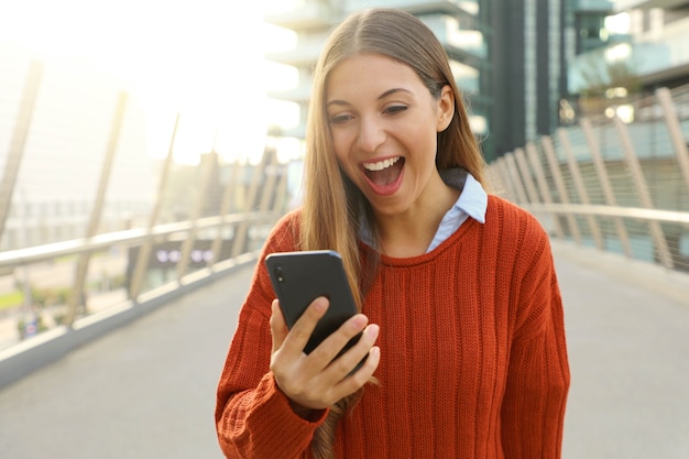 彼女のスマートフォンを屋外で使う女性