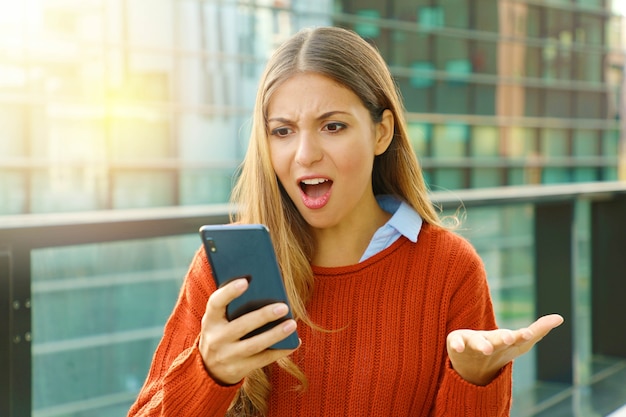 彼女のスマートフォンを屋外で使う女性