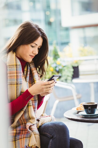 女性が彼女のスマートフォンを使用して