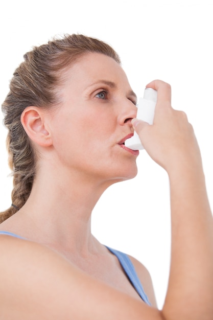 Woman using inhaler for asthma