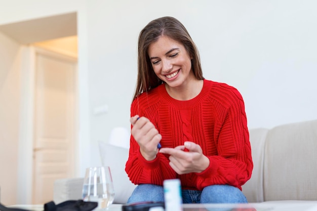 Woman using lancelet on finger woman doing blood sugar test at home in a living room