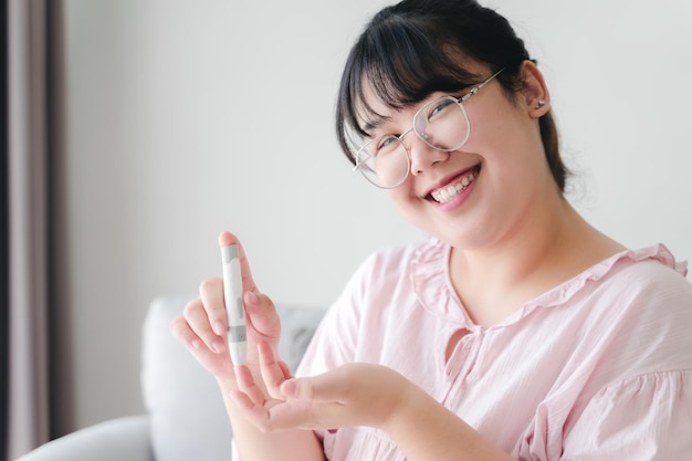 woman using lancet on finger for checking blood sugar level by Glucose meter diabetes glycemia