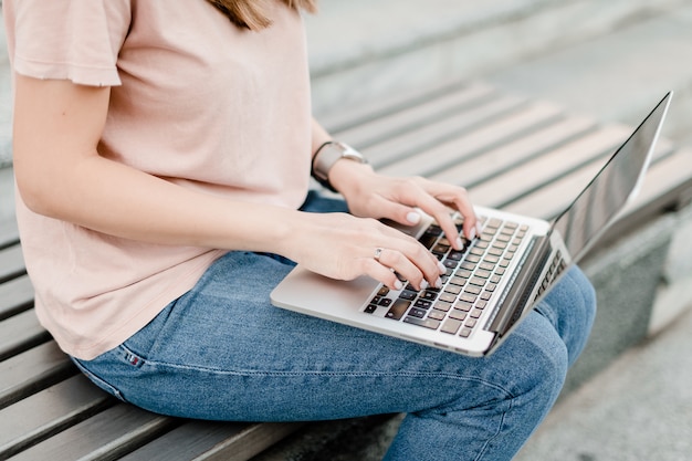 Woman using laptop on the bench