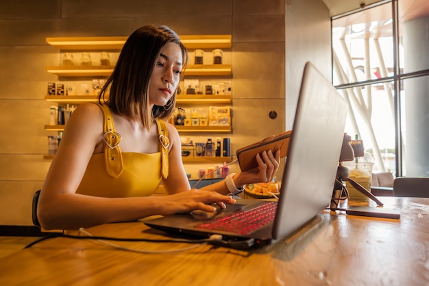 カフェでラップトップコンピューターを使用して女性