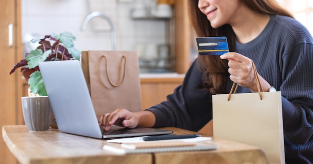 A woman using laptop computer and credit card for online shopping at home