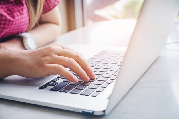 Woman using laptop computer. Female working on laptop in an outdoor cafe.