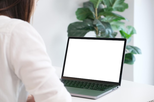 Woman using laptop computer with blank screen for mock up template background