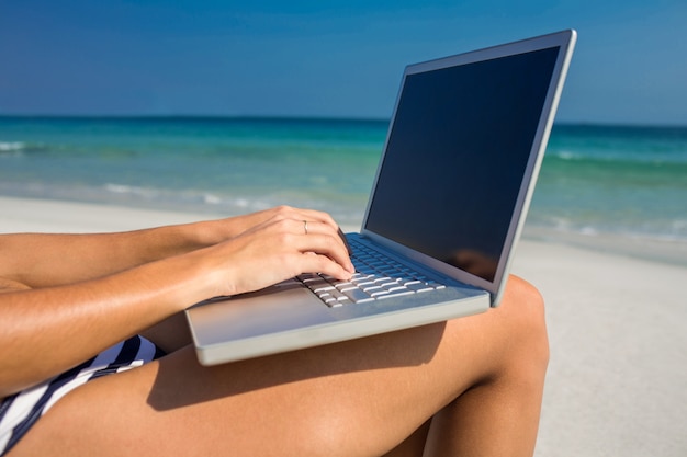 Woman using laptop on deck chair 