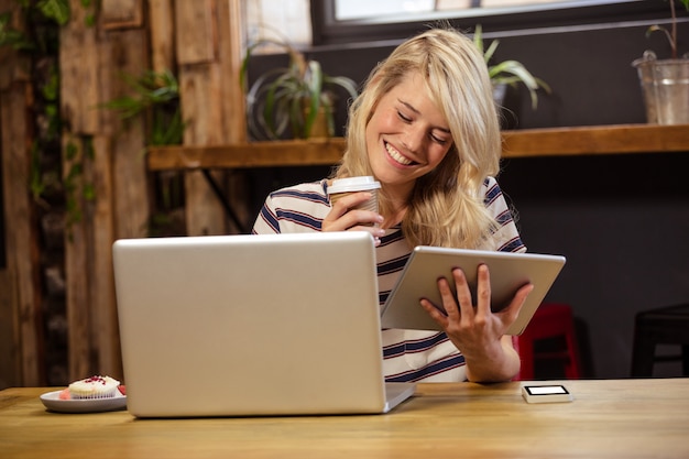 ノートパソコンとデジタルタブレットを使用して女性