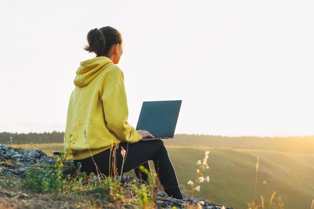 Photo woman using laptop on field