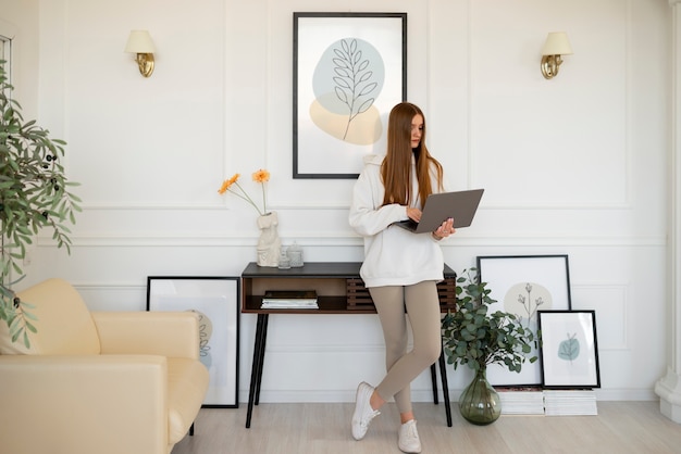 Photo woman using laptop in minimal decorated room