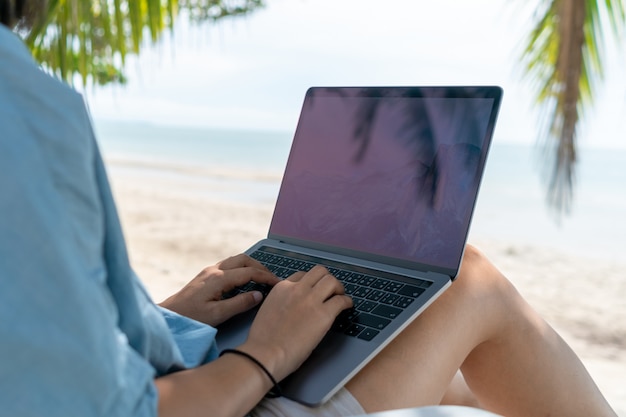 Woman using laptop and smartphone in vacation