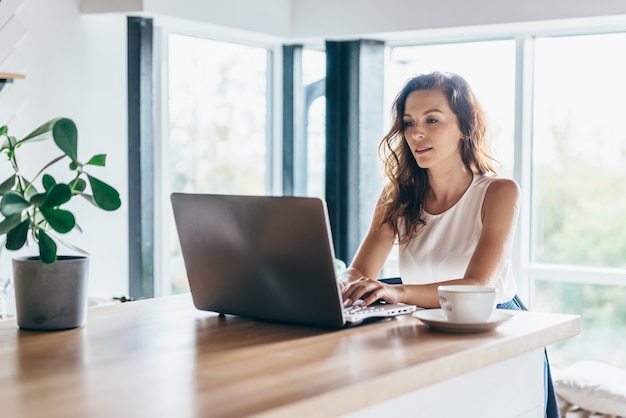 Woman using laptop while sitting at home.