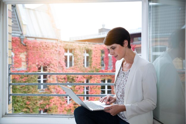 Woman using laptop at the window