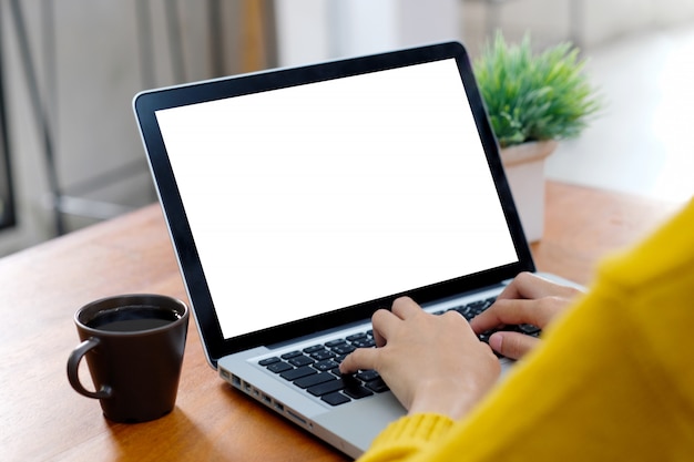 Woman using a laptop with blank screen