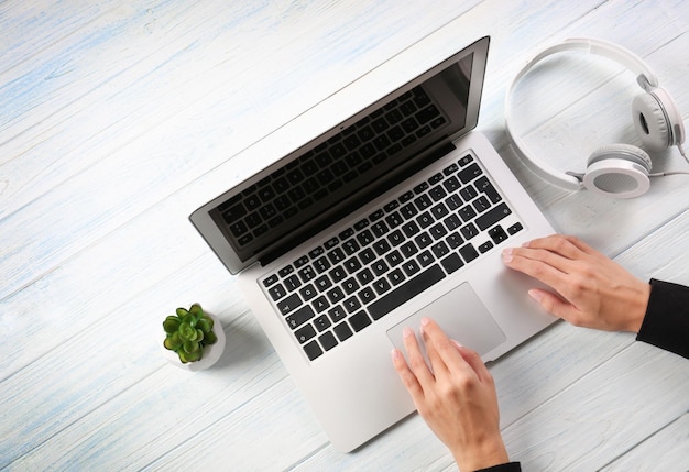 Woman using laptop on wooden background