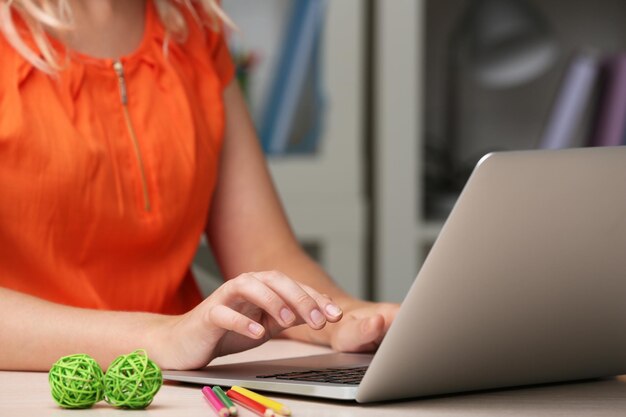 Foto donna che per mezzo del computer portatile sulla fine del posto di lavoro su