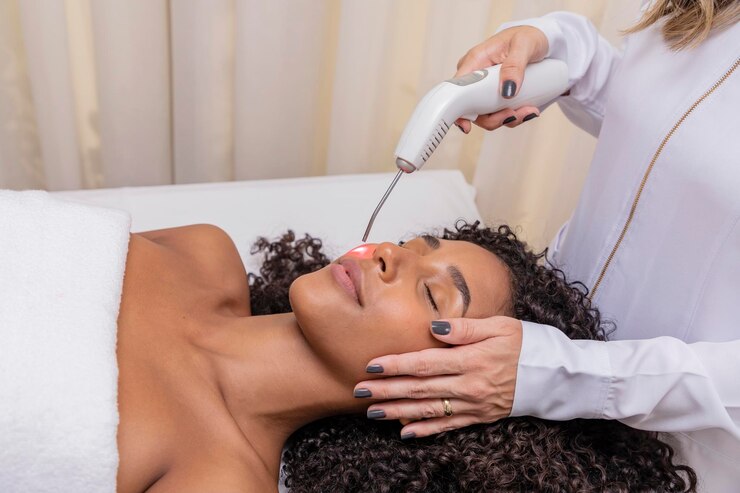 Woman using laser in aesthetic clinic for facial scar
