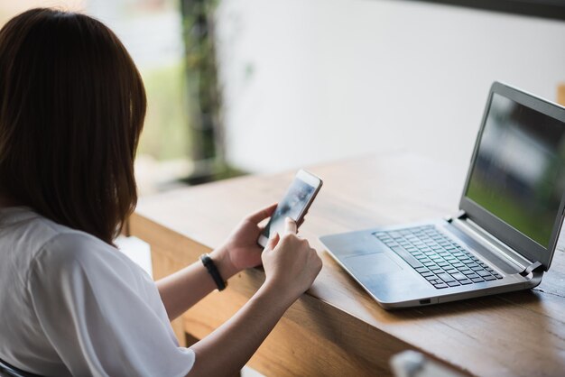 写真 テーブルで携帯電話を使っている女性