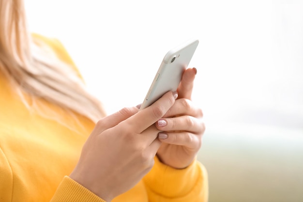 Woman using mobile phone on blurred background