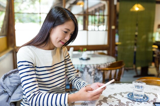 カフェで携帯電話を使用して女性