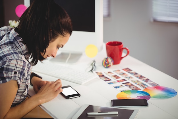 Donna che utilizza telefono cellulare nel ffice creativo