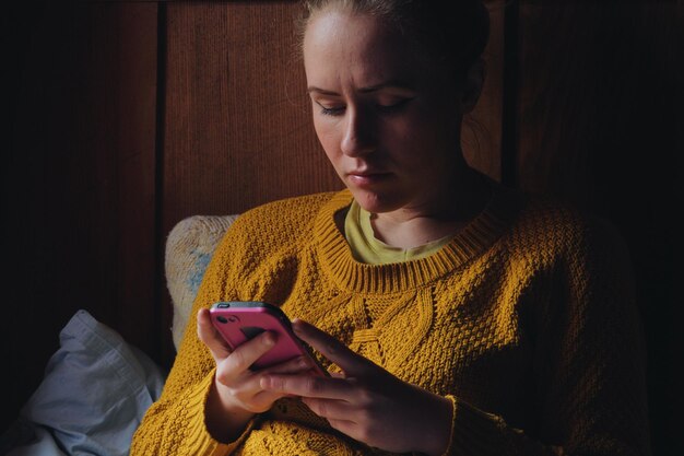 Photo woman using mobile phone at home