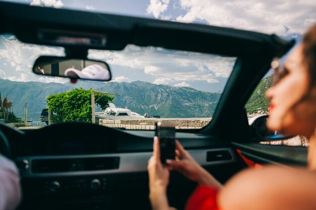 写真 車内で携帯電話を使用する女性
