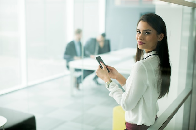 Donna che utilizza il telefono cellulare in ufficio