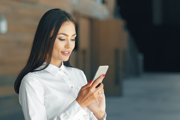 Donna che utilizza il telefono cellulare in ufficio