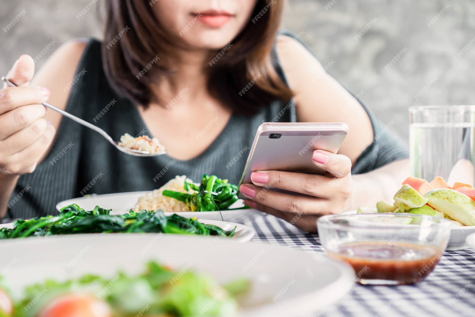 Premium Photo | Woman using mobile phone while eating dinner