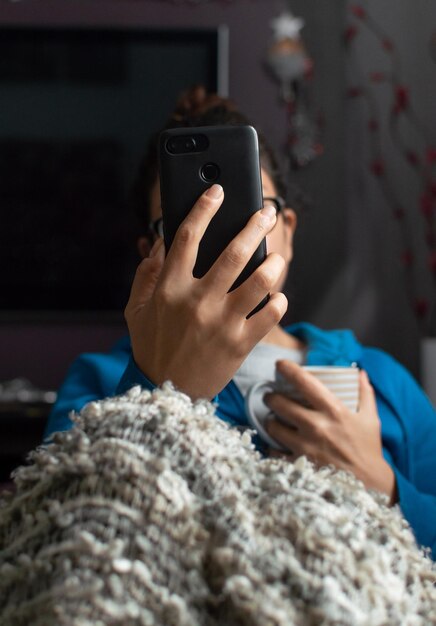 Woman using mobile phone while sitting at home