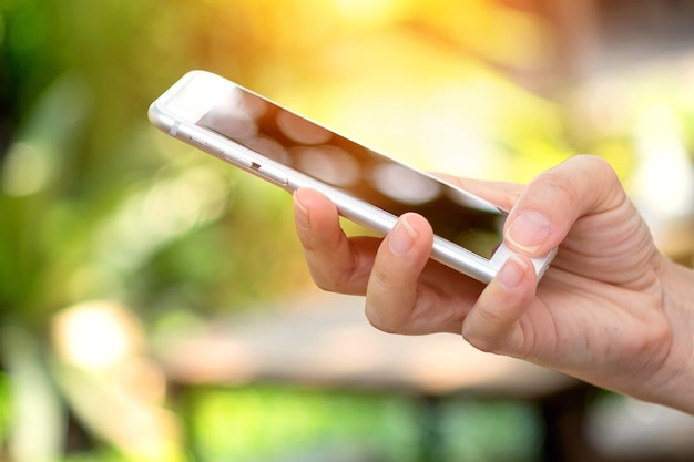 woman using mobile smart-phone outdoor in nature background