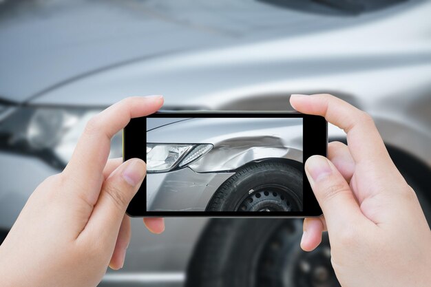 写真 スマートフォンを使って写真を撮る女性自動車事故