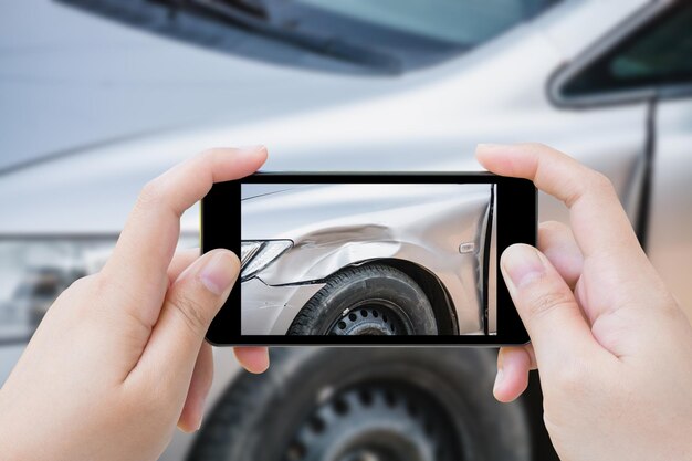 写真 スマートフォンを使って写真を撮る女性自動車事故