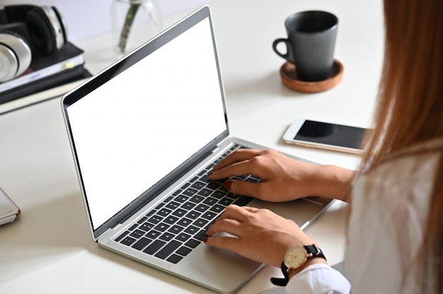 Woman using mockup laptop computer on office desk