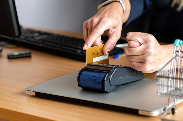 Photo woman using payment card terminal to shop online with credit card and show a fig with his other hand