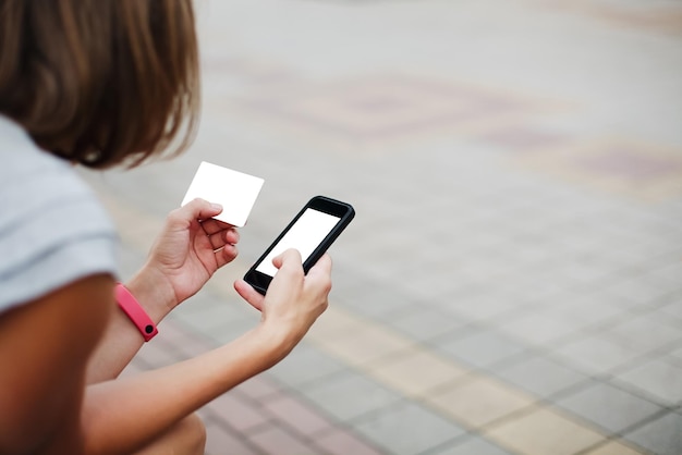 Woman using phone and card for shopping