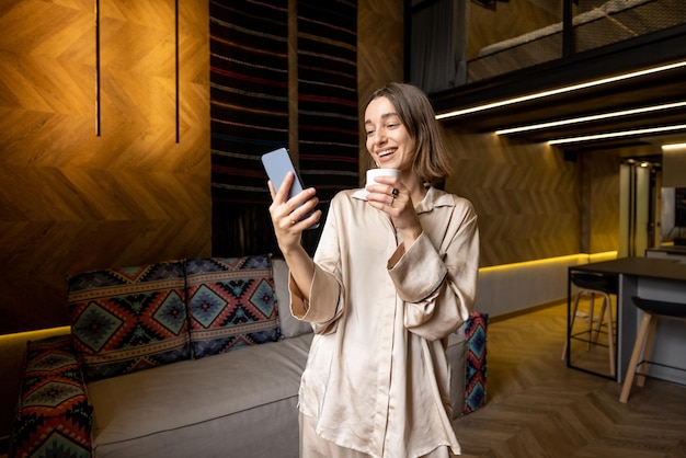 Woman using phone at modern apartment