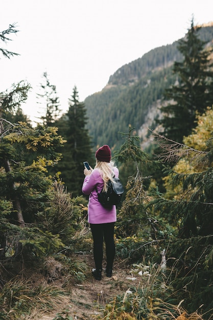 A woman using a phone in the mountains to see her location