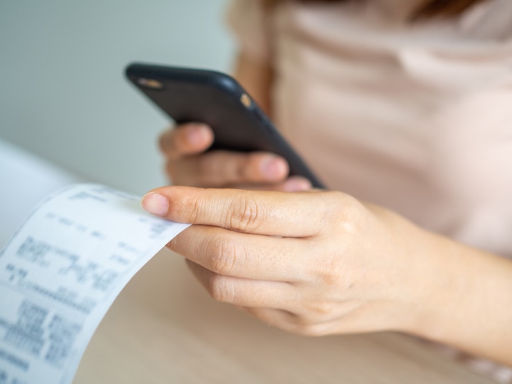Photo woman using phone to scan barcode