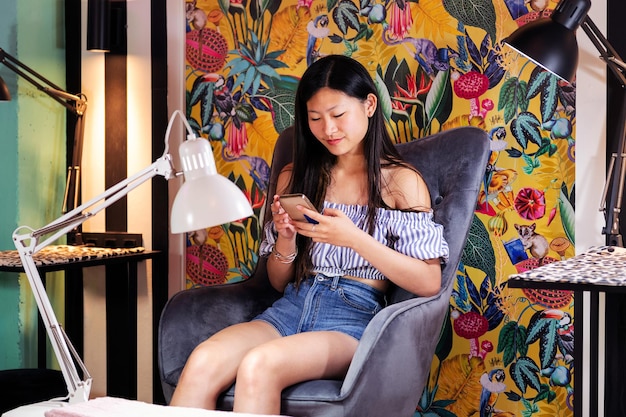 Woman using phone sitting on a beauty salon chair